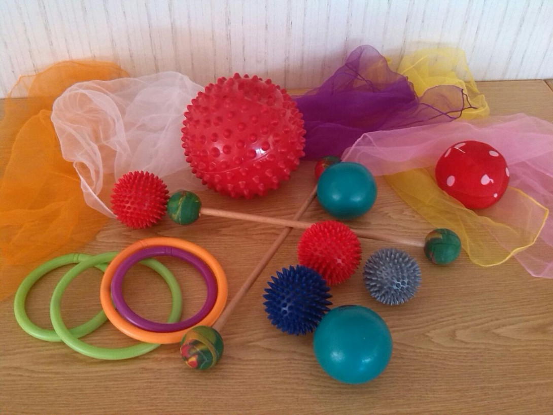 bunte Gymnastik-Bälle, -Tücher und -Ringe auf einem Tisch