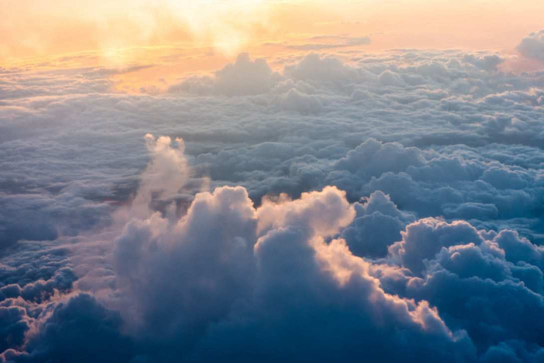 Blick von oben auf die Wolkendecke. Abendsonne am Horizont.